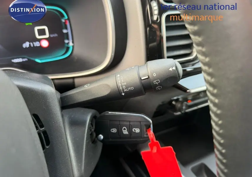 Gros plan sur la commande d’essuie-glace et clé avec porte-clés rouge dans l’habitacle d’un Citroën C5 Aircross blanc nacré.