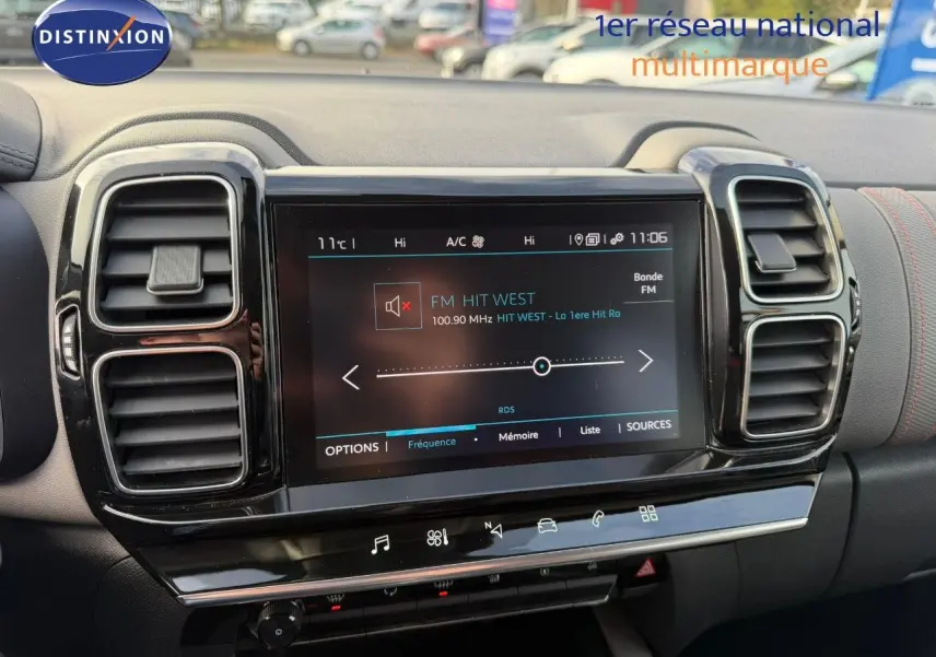 Vue intérieure centrée sur l’écran tactile et les aérateurs du tableau de bord du Citroën C5 Aircross blanc nacré.