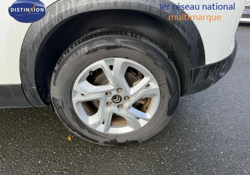 Gros plan sur la roue avant droite d'un Citroën C5 Aircross blanc nacré avec jante alliage et pneus Michelin.