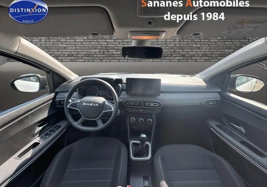 Vue intérieure avant du Dacia Jogger blanc, volant multifonction, écran tactile et levier de vitesses manuel visibles.
