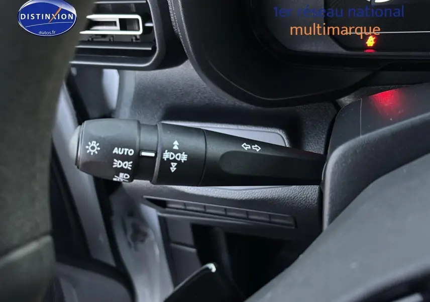 Gros plan sur la commande des feux et clignotants côté gauche du tableau de bord d'un Citroën Berlingo Fourgon blanc 2025.