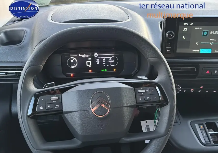 Vue rapprochée du volant multifonction noir et du tableau de bord digital du Citroën Berlingo Fourgon blanc 2025.