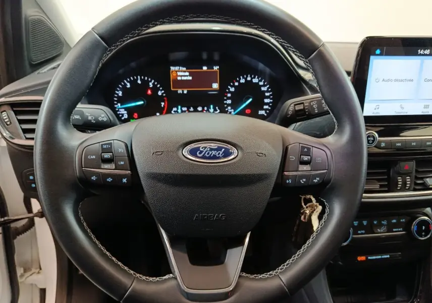 Vue centrée sur le volant cuir noir de la Ford Puma 2022 avec tableau de bord et écran tactile allumé.