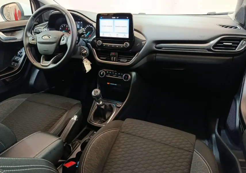 Intérieur de la Ford Puma 2022 vu côté conducteur, tableau de bord noir avec écran tactile central et boîte manuelle.