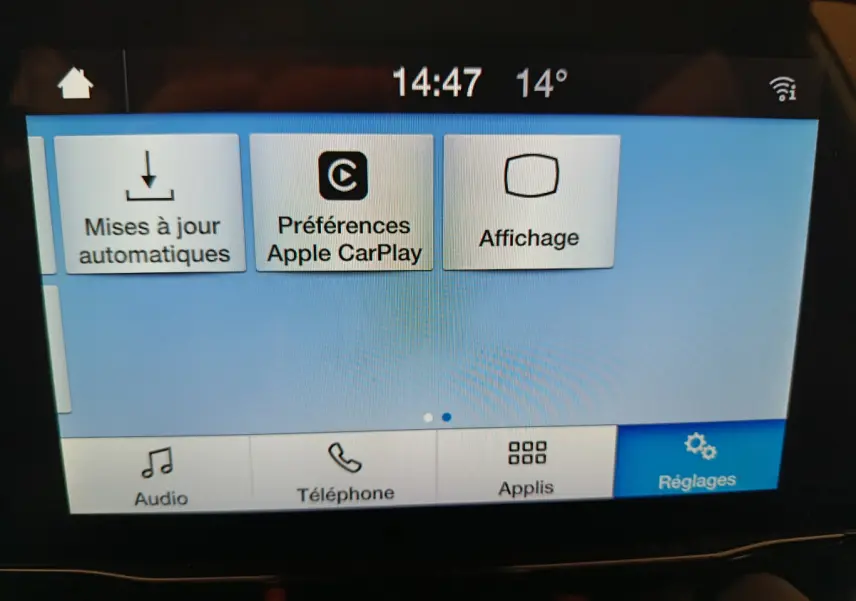 Écran tactile central du Ford Puma blanc 2022 affichant les réglages Apple CarPlay et mises à jour automatiques.