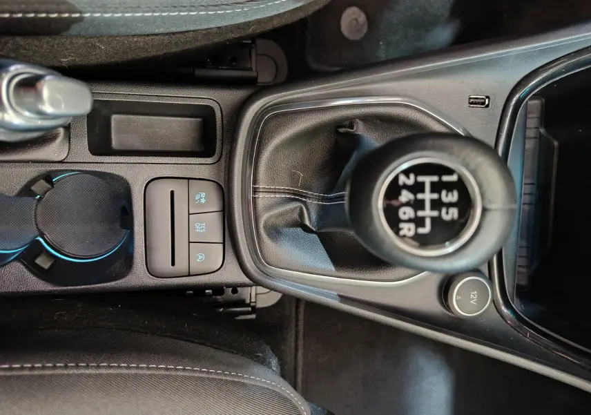 Gros plan sur la console centrale noire du Ford Puma 2022, mettant en valeur le levier de vitesses manuel et les commandes adjacentes.