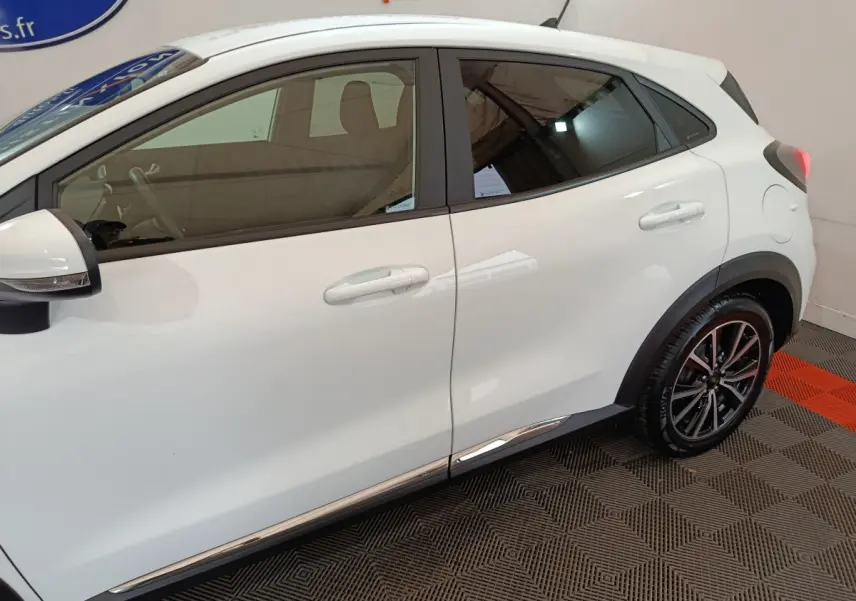 Vue latérale droite du Ford Puma blanc 2022, mettant en valeur les jantes alliage et les contours chromés.