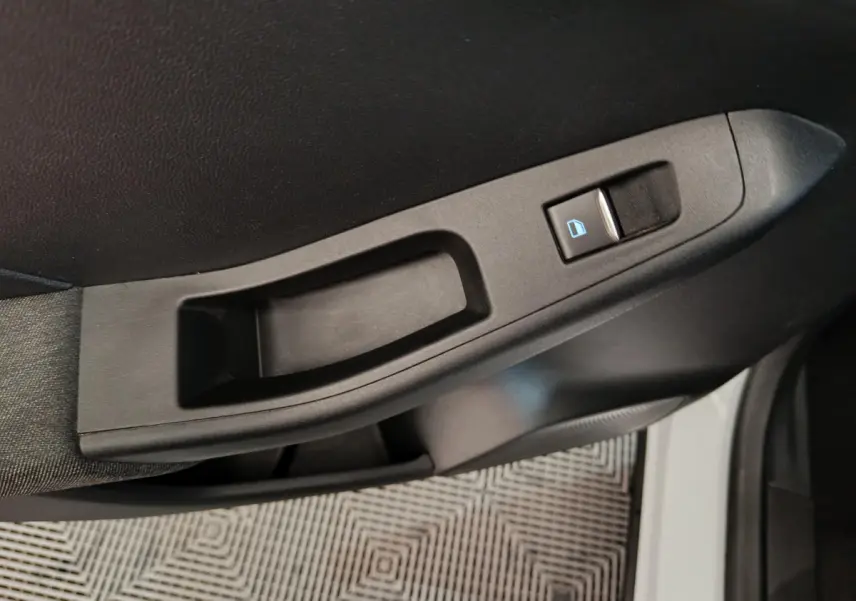 Poignée intérieure côté gauche avec bouton de verrouillage sur porte avant d'une Ford Puma blanche 2022.