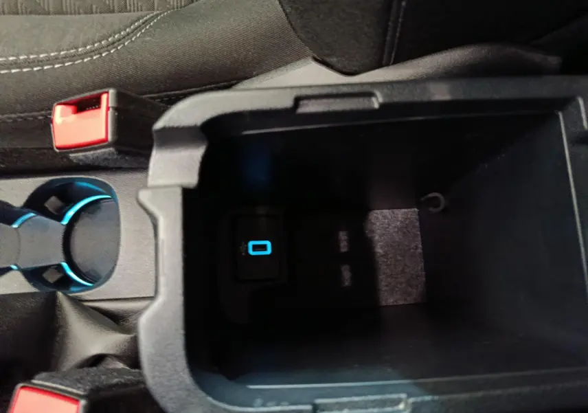 Vue rapprochée de la console centrale noire du Ford Puma 2022 montrant un port USB éclairé en bleu.
