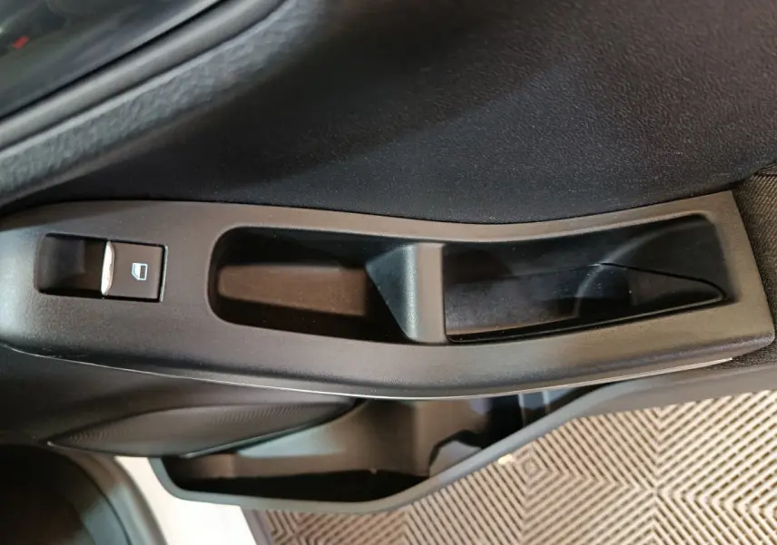 Poignée intérieure de porte côté gauche noire avec commande de lève-vitre sur Ford Puma blanc 2022.