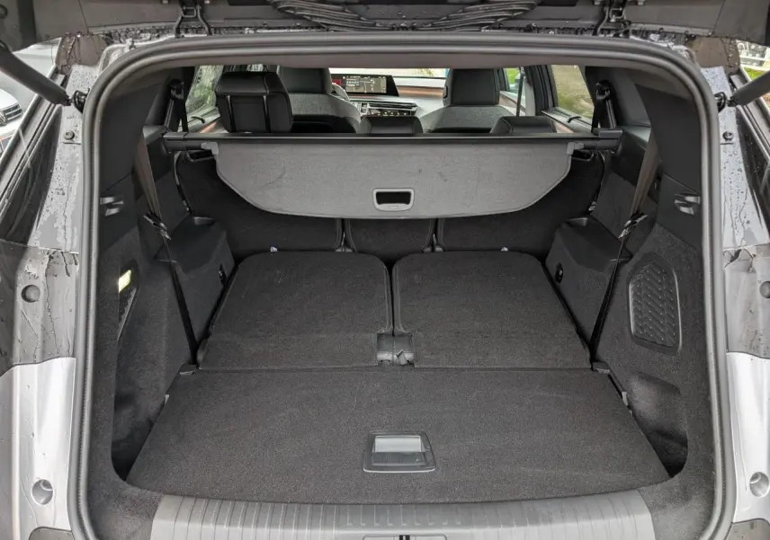 Coffre ouvert du Peugeot 5008 gris, banquette arrière rabattue offrant un espace de chargement plat et spacieux.