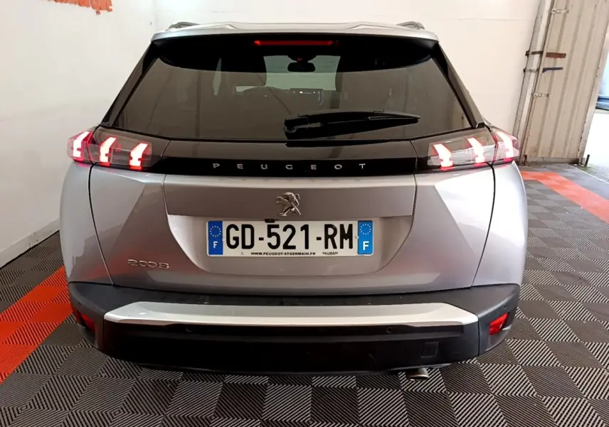 Vue arrière d’un Peugeot 2008 gris clair de 2021 avec feux LED allumés et plaque d’immatriculation française.
