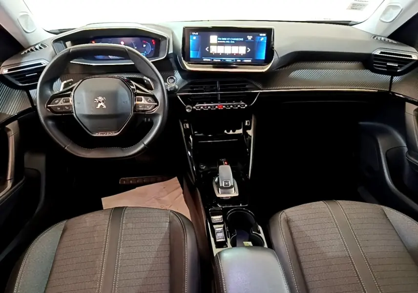 Vue intérieure avant du Peugeot 2008 2021, tableau de bord avec écran tactile 10 pouces et volant cuir multifonctions.