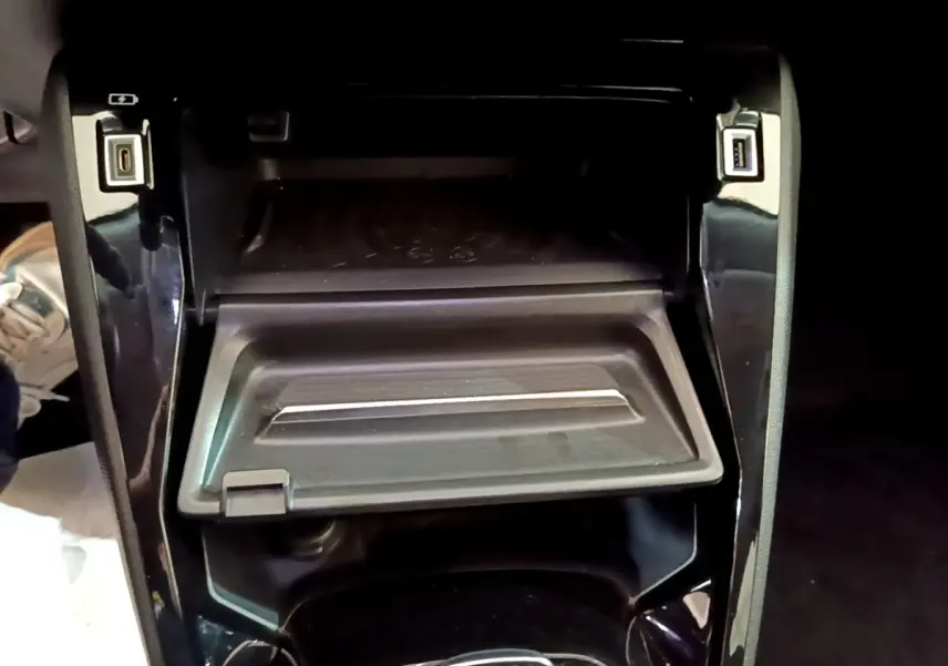 Gros plan sur la console centrale noire du Peugeot 2008 1.5 BlueHDi, avec compartiment ouvert et ports USB visibles.