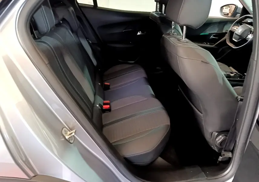 Vue intérieure côté gauche arrière du Peugeot 2008 gris clair, montrant la banquette arrière et partie avant cuir noir.