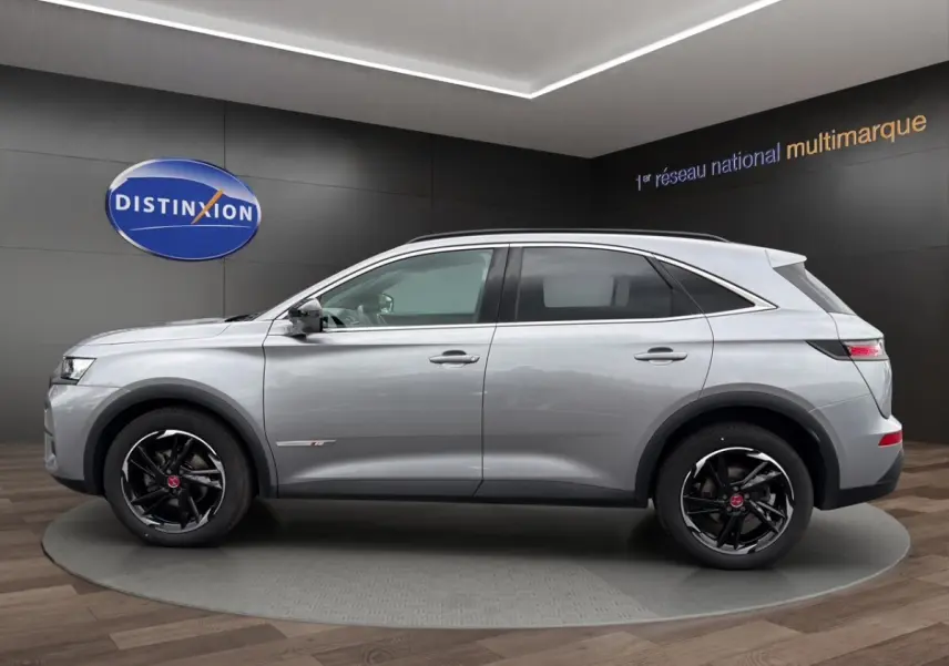 Vue de profil côté gauche du SUV DS7 Crossback gris clair avec jantes noires et détails chromés.