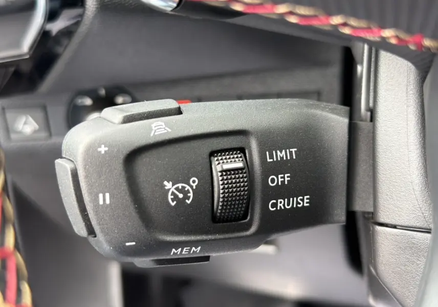 Gros plan sur la commande de régulateur de vitesse au volant cuir du DS7 Crossback gris clair 2022.