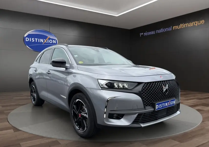 DS7 Crossback gris clair en 3/4 avant droit, avec calandre noire et jantes noires brillantes distinctives.
