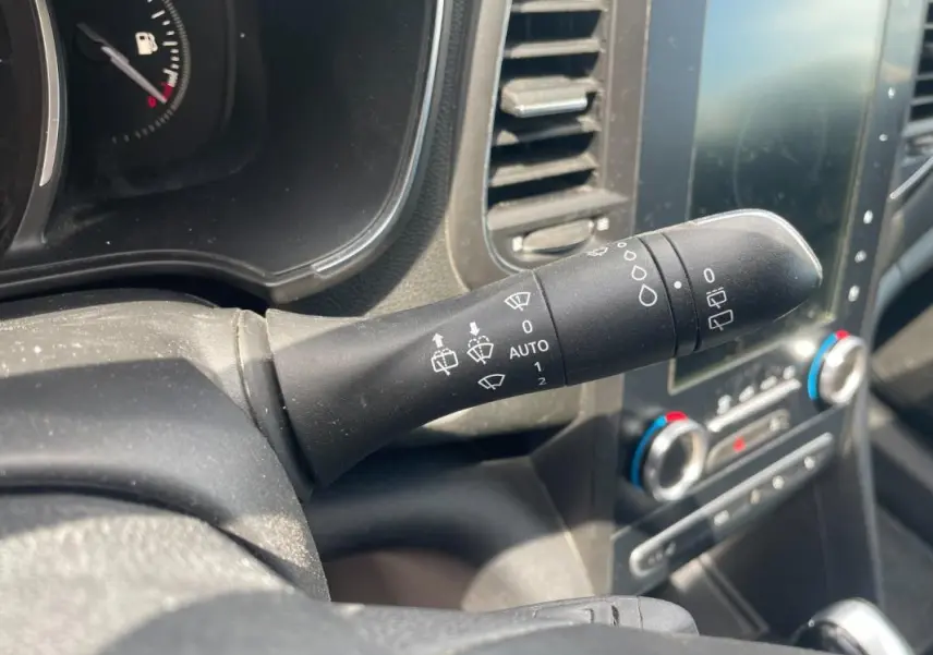 Gros plan sur la commande d’essuie-glace noire dans l’habitacle d’une Renault Mégane IV blanche de 2016.