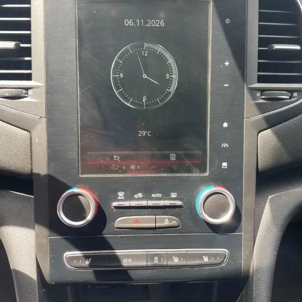 Vue rapprochée de la console centrale de la Renault Mégane IV avec écran tactile, commandes climatisation et boîte auto visible.