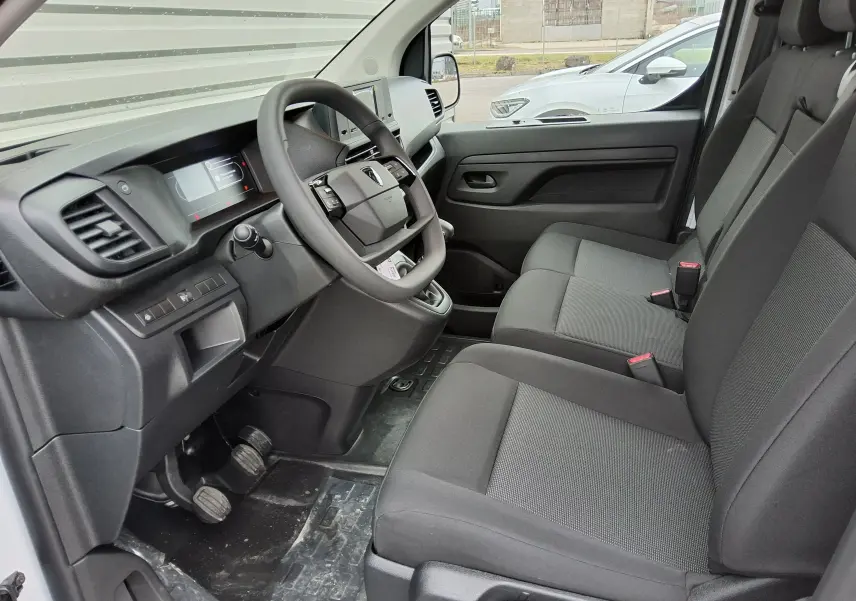 Vue intérieure côté conducteur du Peugeot Expert Fourgon blanc 2025, montrant le tableau de bord et la banquette passager 2 places.