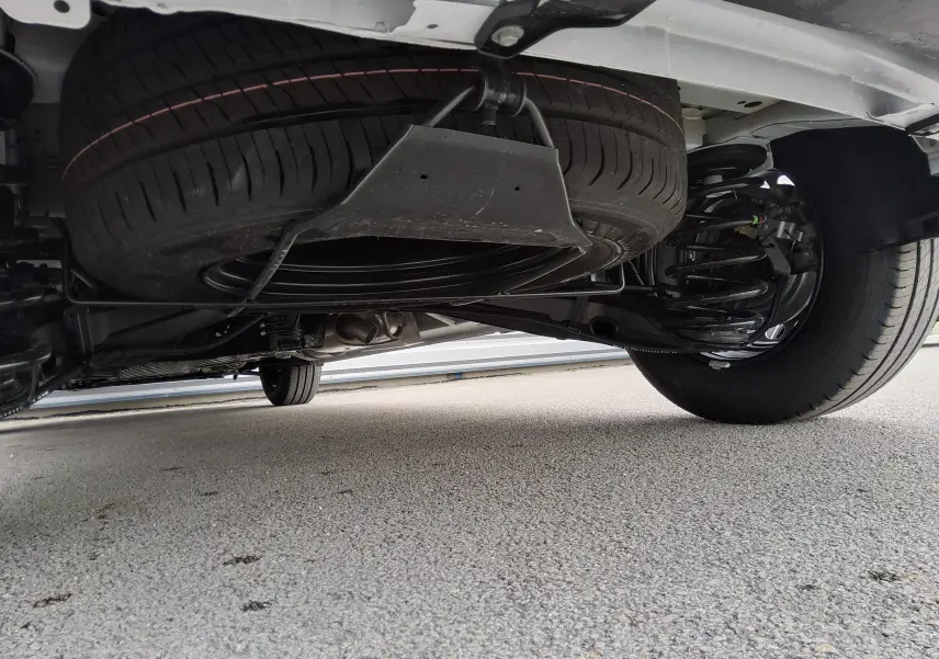 Vue sous le Peugeot Expert Fourgon blanc 2025 montrant la roue de secours suspendue sous le châssis arrière droit.