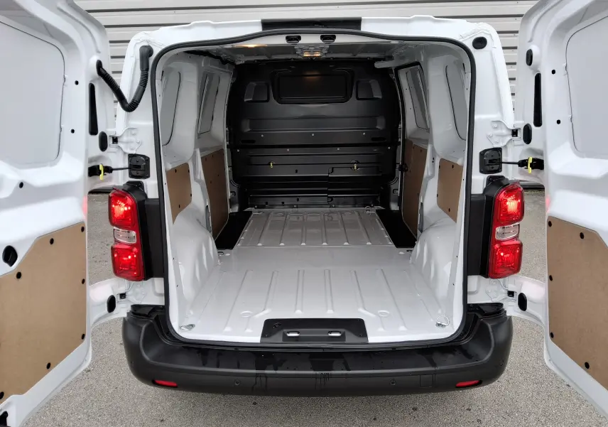 Vue arrière du Peugeot Expert Fourgon blanc 2025 avec portes ouvertes montrant la grande zone de chargement vide et protégée.