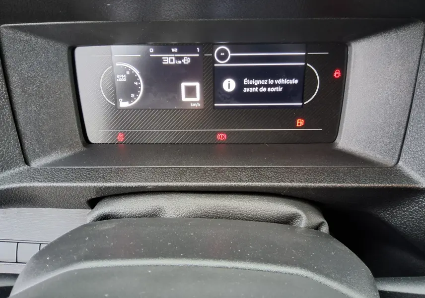 Vue rapprochée du tableau de bord numérique du Peugeot Expert Fourgon 2025, affichant un message d'alerte et compte-tours.
