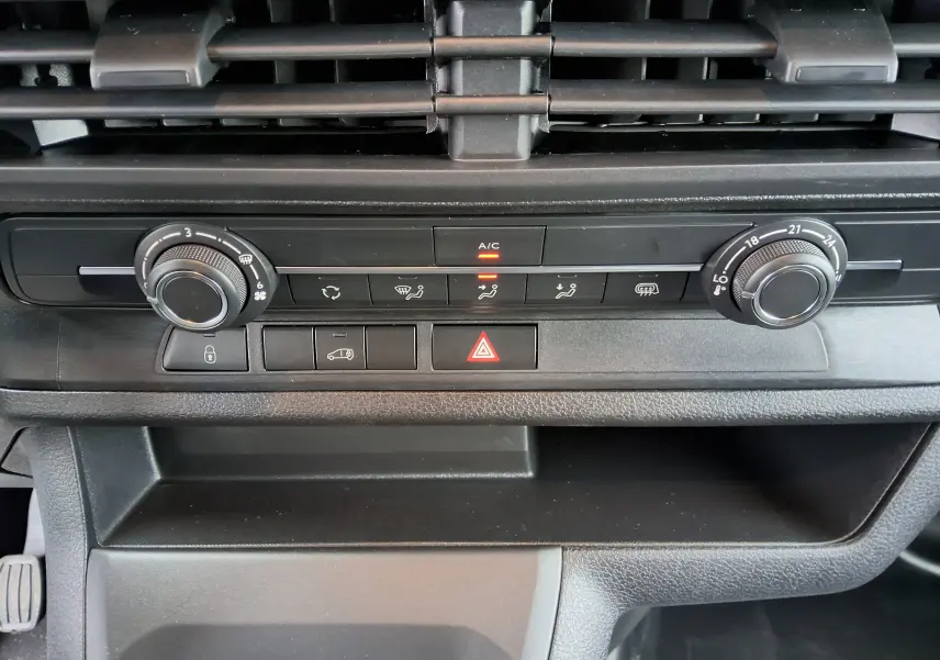 Gros plan sur la console centrale noire du Peugeot Expert Fourgon blanc 2025, avec commandes climatisation et ventilation.