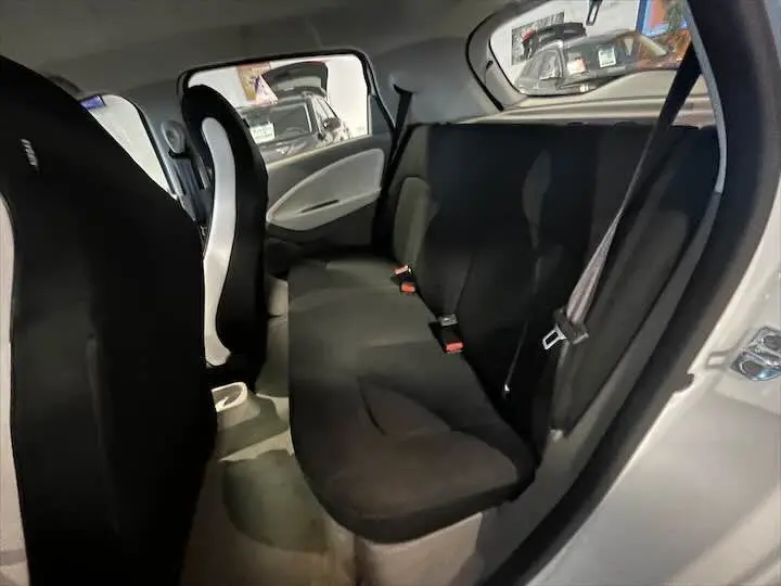 Vue intérieure arrière de la Renault ZOE blanc glacier, montrant la banquette noire et les ceintures de sécurité.