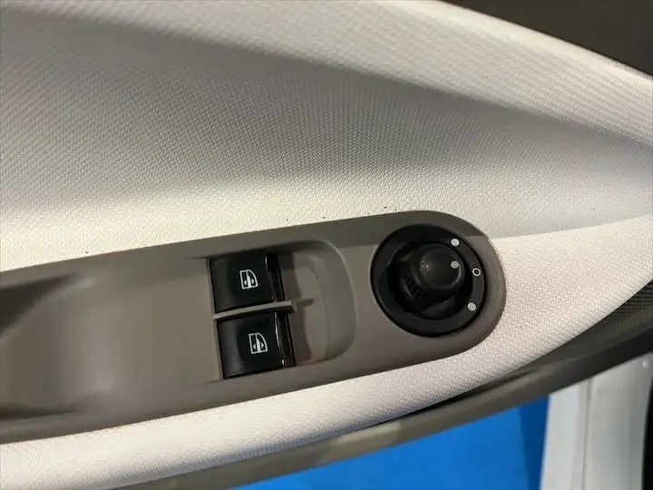 Commande des vitres électriques et réglage des rétroviseurs sur la porte côté conducteur d'une Renault ZOE blanc glacier.