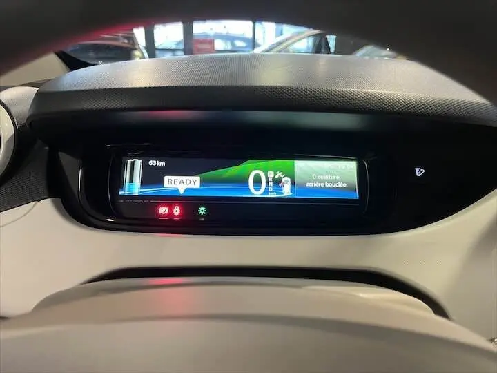 Affichage numérique du tableau de bord de la Renault ZOE blanc glacier, indiquant 63 km d'autonomie restante.