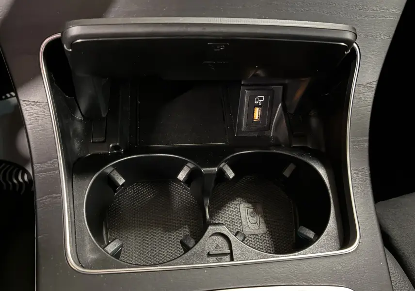 Gros plan sur les porte-gobelets et prise USB intégrés dans la console centrale du Mercedes Classe C Break noir métal.