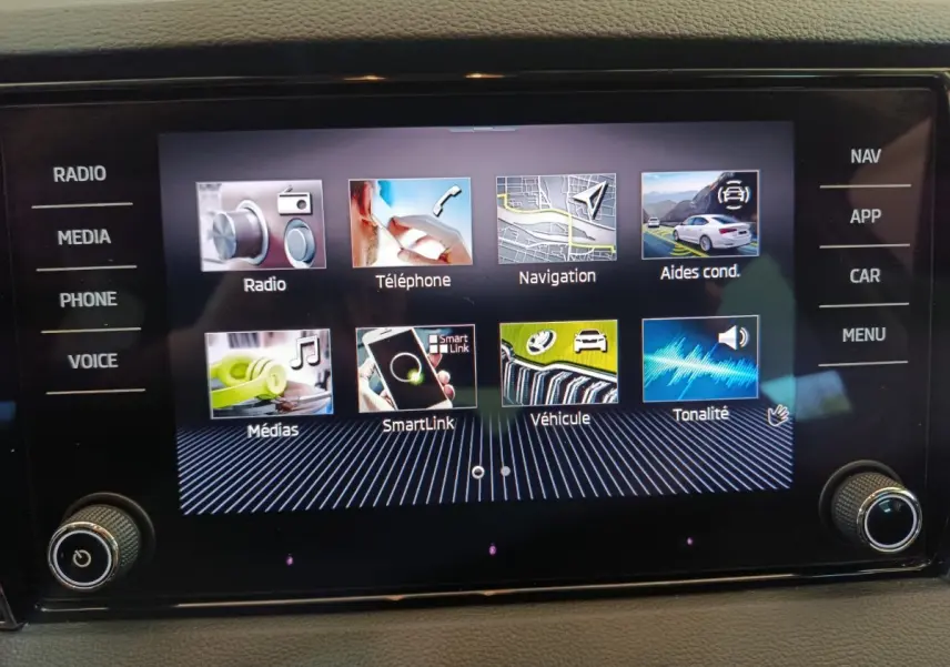 Écran tactile central du Skoda Karoq 2024 affichant les menus radio, téléphone, navigation et aides à la conduite.