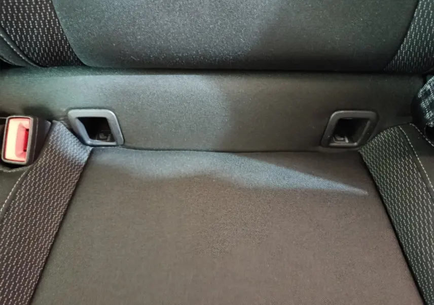 Gros plan sur la banquette arrière noire du Skoda Karoq 2024, montrant les ancrages Isofix et la ceinture de sécurité.