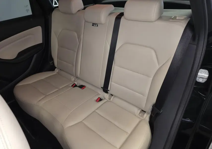 Vue intérieure côté arrière droit montrant la banquette beige clair en similicuir de la Mercedes Classe B noire.