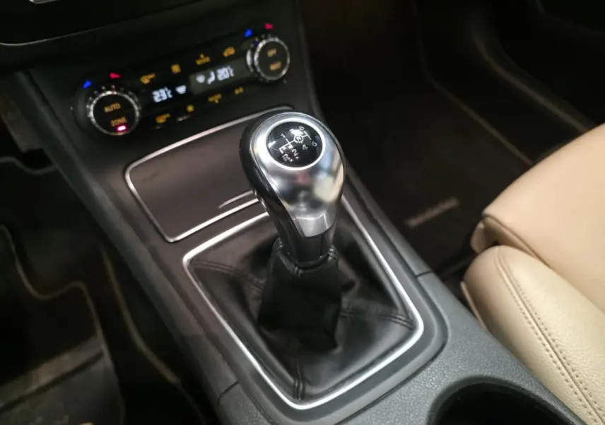 Gros plan sur le levier de vitesses manuel noir et argenté de la Mercedes Classe B 180 d Intuition, avec console centrale et siège beige visible.