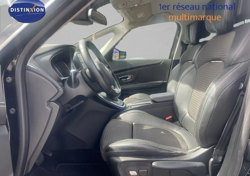 Vue intérieure côté conducteur du Renault Scénic IV noir de 2017, avec sièges en tissu et cuir et volant multifonction.