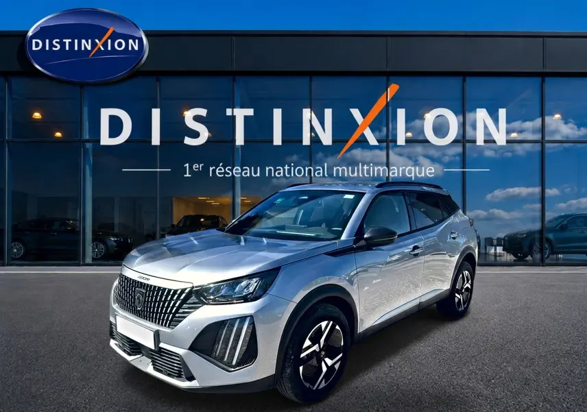 Peugeot 2008 gris artense en 3/4 avant droit, avec jantes alu et toit noir devant showroom Distinxion.