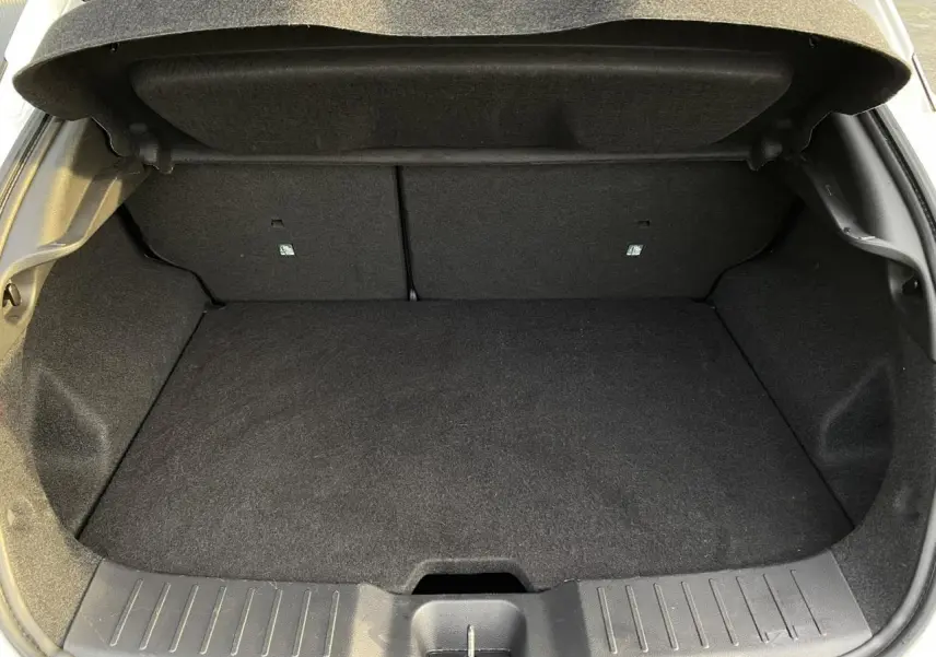 Coffre ouvert en vue arrière d'une Nissan Juke blanc perle 2024, montrant un espace de chargement propre et spacieux.