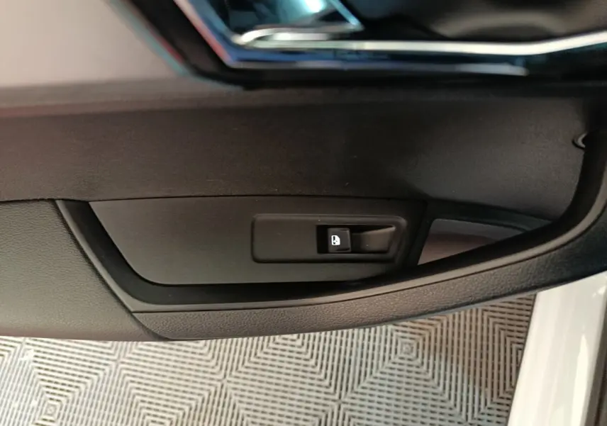 Détail de la commande d'ouverture de trappe à carburant sur la porte côté conducteur d'un Skoda Karoq blanc 2024.