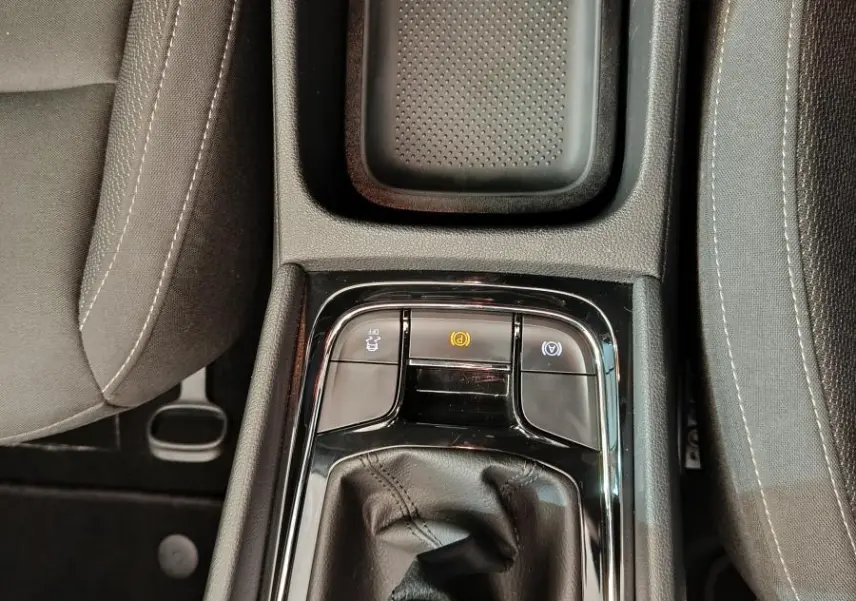 Vue plongeante sur la console centrale noire du Skoda Karoq blanc 2024, avec levier de vitesse manuel et commandes électroniques.