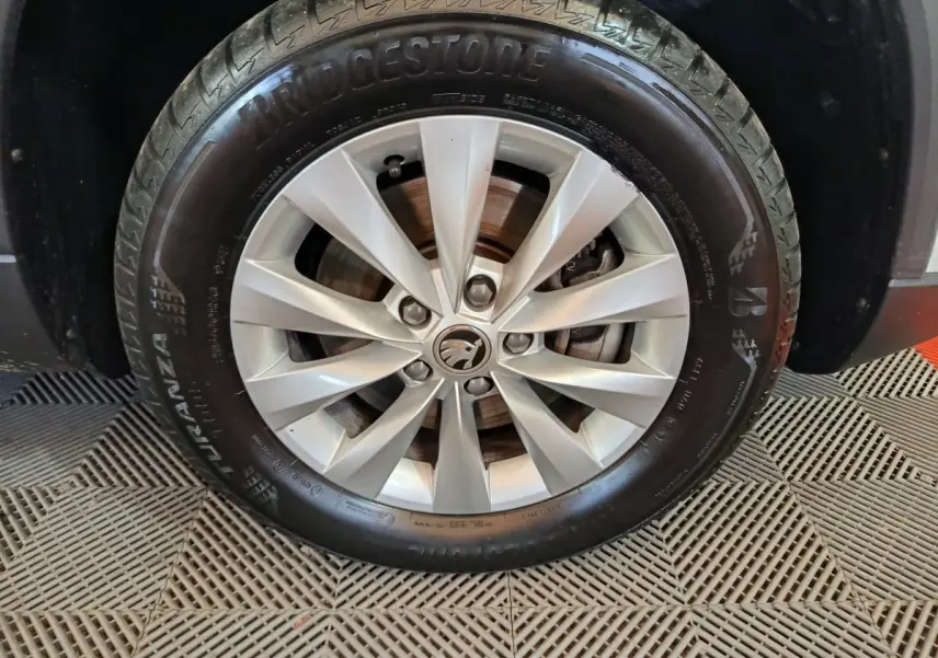 Gros plan sur la roue avant droite d'un Skoda Karoq blanc 2024 avec jante alliage et pneu Bridgestone.