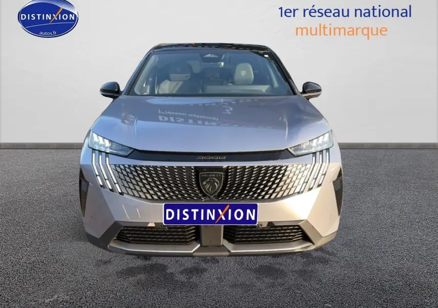 Vue frontale d’un Peugeot 3008 gris 2025 avec calandre distinctive et phares LED verticaux allumés.