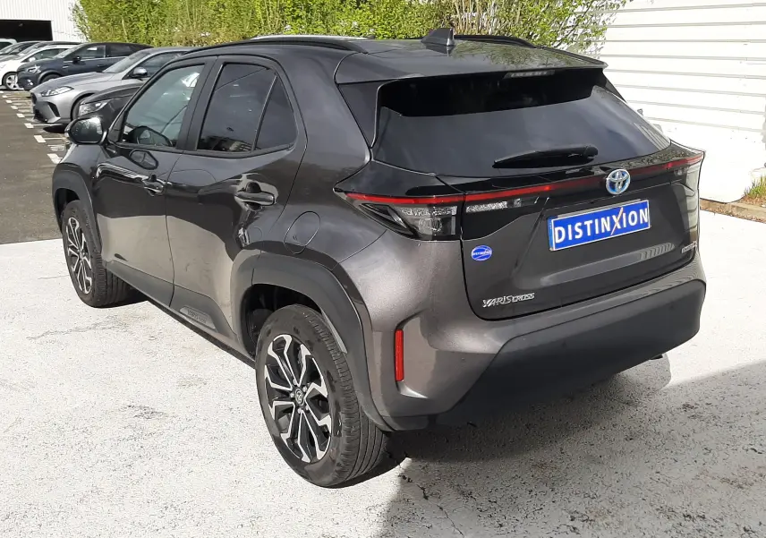 Vue 3/4 arrière droite d'une Toyota Yaris Cross 2024 gris atlas métal avec jantes alliage et feux arrière LED.
