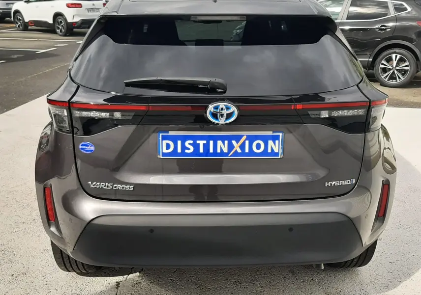 Vue arrière d'une Toyota Yaris Cross 1.5 Hybride gris atlas métal, avec feux LED et logo hybride bien visibles.