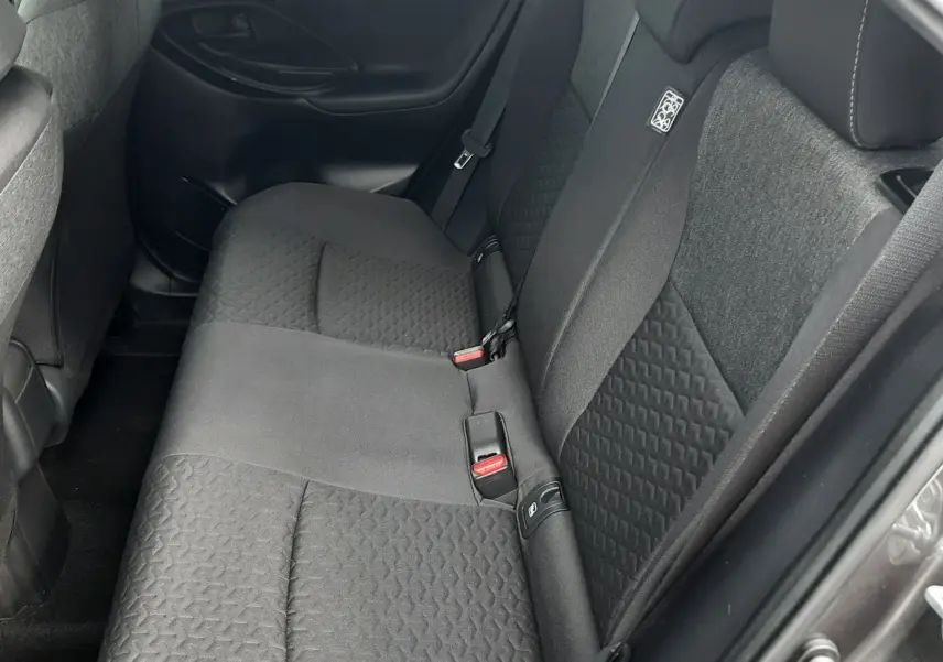 Vue intérieure côté droit des sièges arrière en tissu gris foncé de la Toyota Yaris Cross 2024 gris atlas métal.