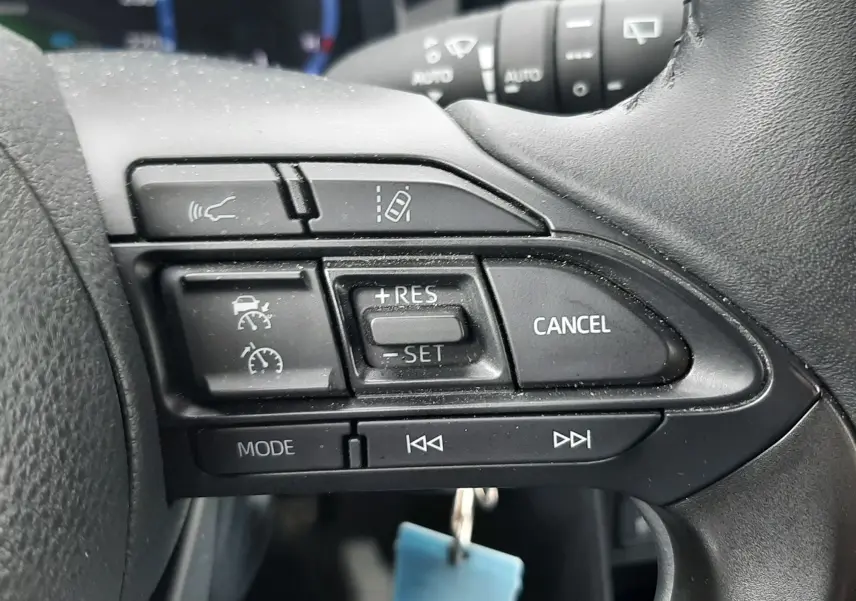 Gros plan sur les commandes au volant côté droit de la Toyota Yaris Cross gris atlas, avec boutons de régulateur et multimédia.