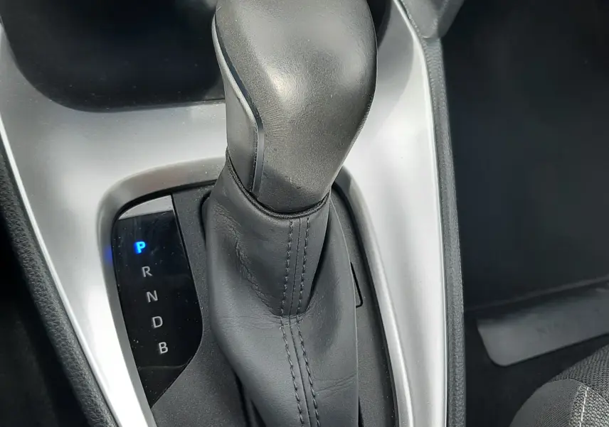 Le levier de vitesse automatique noir de la Toyota Yaris Cross 2024, avec indication des modes éclairée en bleu.