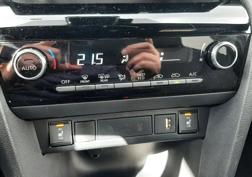Détail du tableau de bord de la Toyota Yaris Cross 2024, montrant la climatisation automatique et les commandes des sièges chauffants.